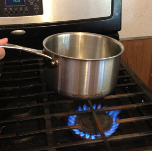 When the pan is directly above the flames, heat is transferred through radiation.